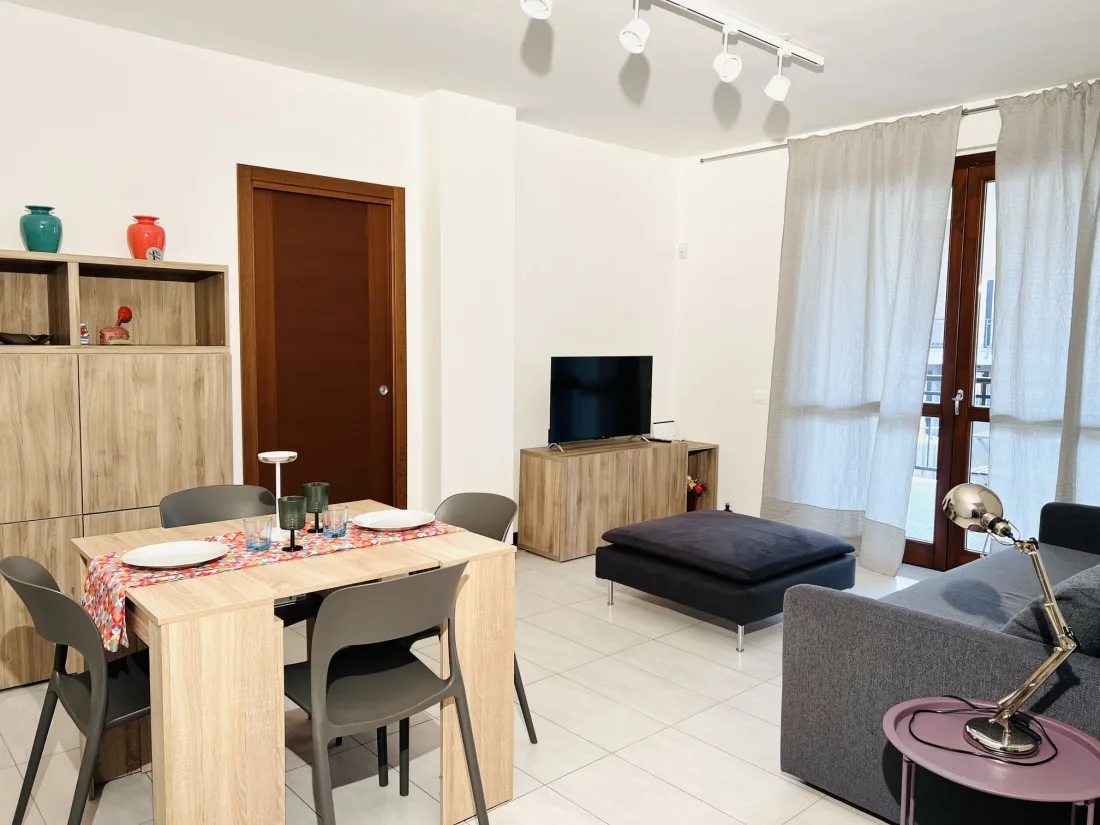Soggiorno di Alli House con tavolo da pranzo e TV